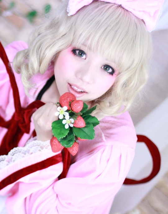1girl bangs blonde_hair blue_eyes blurry blurry_background blurry_foreground bow choker depth_of_field flower food fruit hinaichigo looking_at_viewer photo ribbon smile solo strawberry strawberry_print striped upper_body