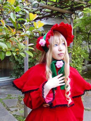 1girl blonde_hair blue_eyes bonnet capelet dress flower lips long_hair outdoors realistic red_capelet red_dress rose shinku solo