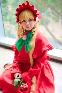 Rating: Safe Score: 0 Tags: 1girl blonde_hair blue_eyes blurry blurry_background bonnet bow bowtie capelet depth_of_field dress flower green_bow green_neckwear long_hair long_sleeves looking_at_viewer photo red_capelet red_dress rose shinku sitting solo User: admin