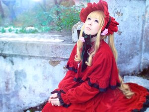 Rating: Safe Score: 0 Tags: 1girl blonde_hair blue_eyes blurry blurry_background bonnet bow capelet depth_of_field dress flower long_hair long_sleeves outdoors red_capelet red_dress shinku sitting solo User: admin