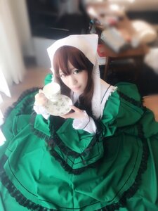 Rating: Safe Score: 0 Tags: 1girl blurry blurry_foreground brown_hair depth_of_field dress frills green_dress long_sleeves looking_at_viewer sitting solo suiseiseki User: admin