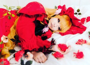 Rating: Safe Score: 0 Tags: 1girl blonde_hair blue_eyes blurry blurry_foreground bonnet bow capelet depth_of_field dress flower long_hair looking_at_viewer red_capelet shinku solo User: admin