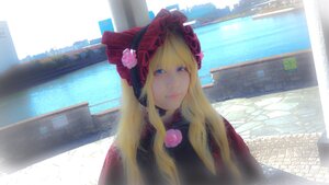 Rating: Safe Score: 0 Tags: 1girl bangs blonde_hair blue_eyes bonnet building city closed_mouth flower long_hair looking_at_viewer pink_flower rose shinku smile solo User: admin