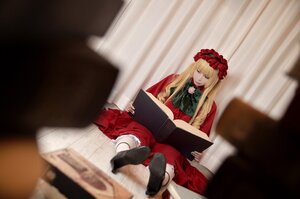 Rating: Safe Score: 0 Tags: 1girl blonde_hair blurry blurry_background blurry_foreground book depth_of_field dress long_hair long_sleeves red_dress shinku sitting solo User: admin