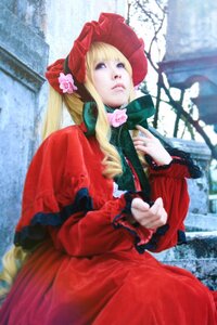 Rating: Safe Score: 0 Tags: 1girl blonde_hair blue_eyes blurry bonnet bow building dress flower frills long_hair long_sleeves outdoors red_dress shinku solo User: admin