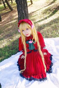 Rating: Safe Score: 0 Tags: 1girl blonde_hair blue_eyes bonnet brooch capelet dress flower lips long_hair long_sleeves looking_at_viewer outdoors red_dress shinku sitting solo User: admin