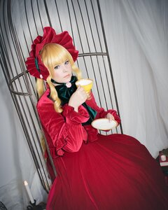 Rating: Safe Score: 0 Tags: 1girl bangs blonde_hair blue_eyes bonnet bow cup curtains dress long_hair long_sleeves looking_at_viewer red_dress saucer shinku solo teacup User: admin
