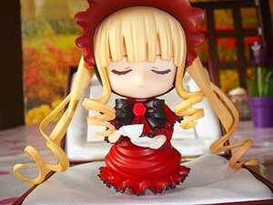 Rating: Safe Score: 0 Tags: 1girl blonde_hair bonnet bookshelf bow chibi closed_eyes cup doll dress flower long_hair long_sleeves rose shinku sitting solo table teacup twintails User: admin