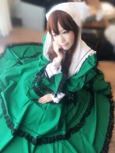 Rating: Safe Score: 0 Tags: 1girl blurry blurry_background brown_hair depth_of_field dress frills green_dress long_sleeves looking_at_viewer sitting smile solo suiseiseki User: admin