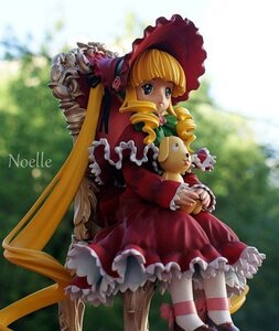 Rating: Safe Score: 0 Tags: 1girl blonde_hair blue_eyes blurry bonnet bow doll dress drill_hair frills long_hair long_sleeves looking_at_viewer outdoors pink_bow red_dress shinku sitting solo twin_drills twintails User: admin