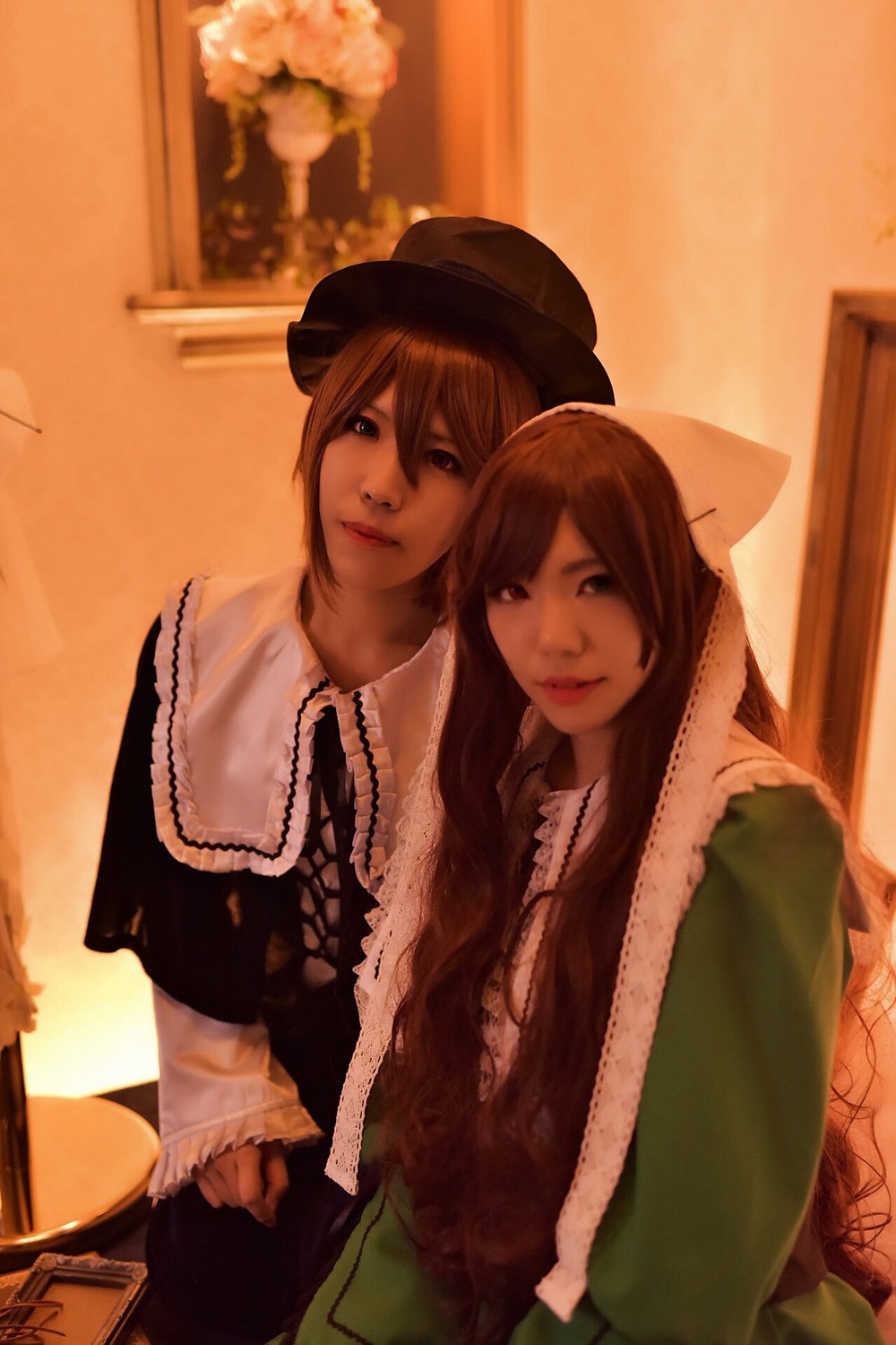 2girls brown_hair capelet dress fur_trim hat indoors lips long_hair looking_at_viewer multiple_cosplay multiple_girls realistic smile tagme