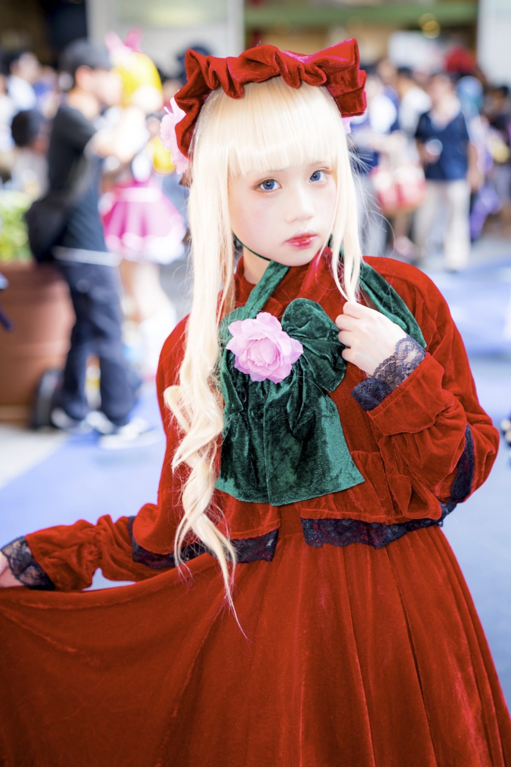 1girl blonde_hair blue_eyes blurry blurry_background blurry_foreground depth_of_field figure flower lips long_hair long_sleeves looking_at_viewer photo shinku solo solo_focus