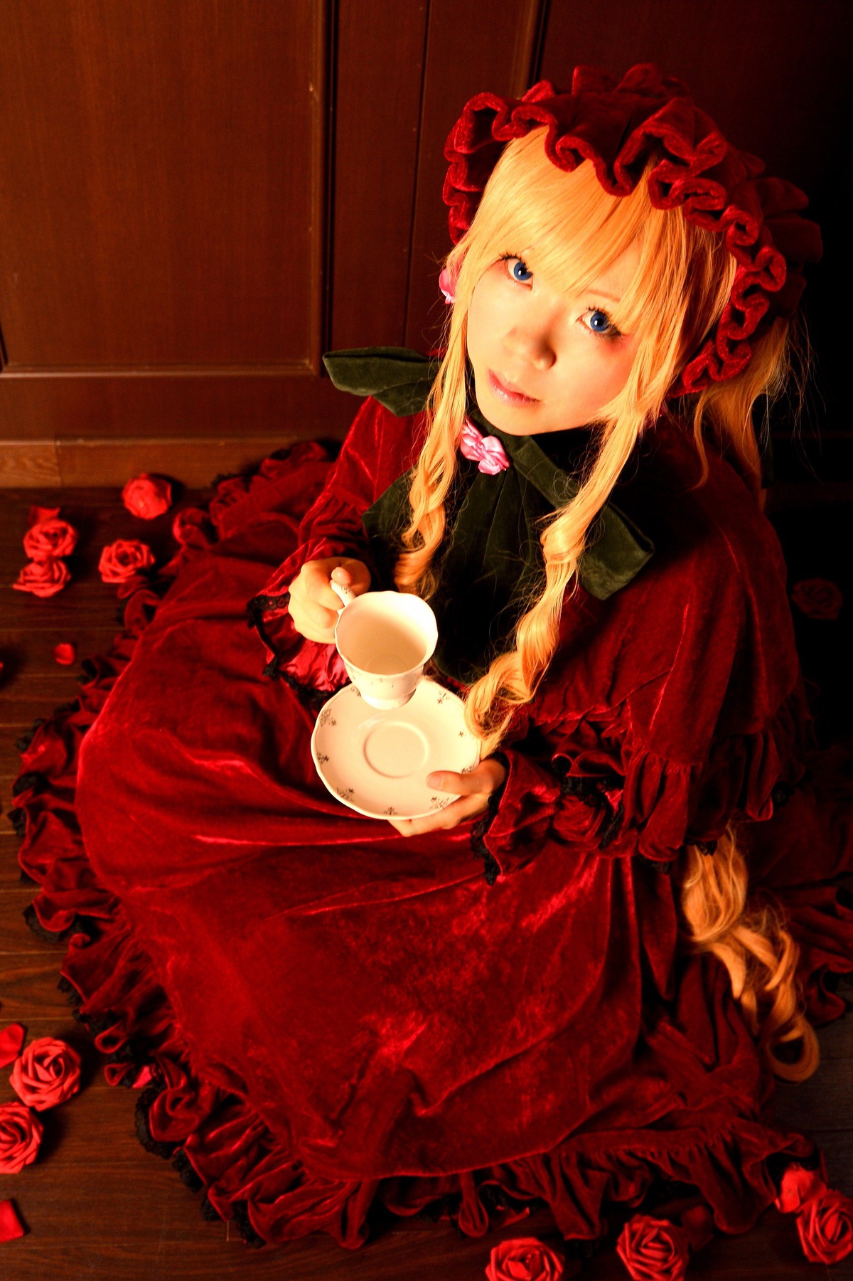 1girl blonde_hair blue_eyes bonnet cup dress flower gothic_lolita holding_cup lips lolita_fashion long_hair looking_at_viewer red_dress red_flower red_rose rose shinku sitting solo tea teacup