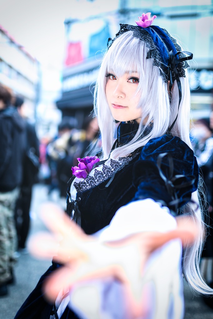 1girl bangs black_dress blurry blurry_background blurry_foreground closed_mouth depth_of_field dress figure gothic_lolita hairband lolita_fashion long_hair long_sleeves looking_at_viewer motion_blur photo red_eyes solo solo_focus suigintou