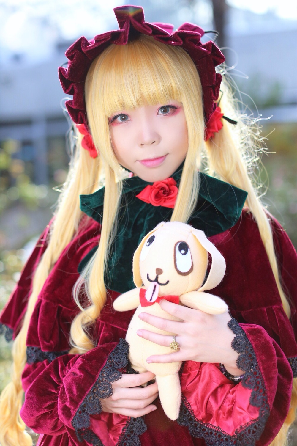 1girl blonde_hair blurry blurry_background bonnet depth_of_field dress flower frills jewelry lips long_hair long_sleeves looking_at_viewer photo red_dress ring rose shinku smile solo