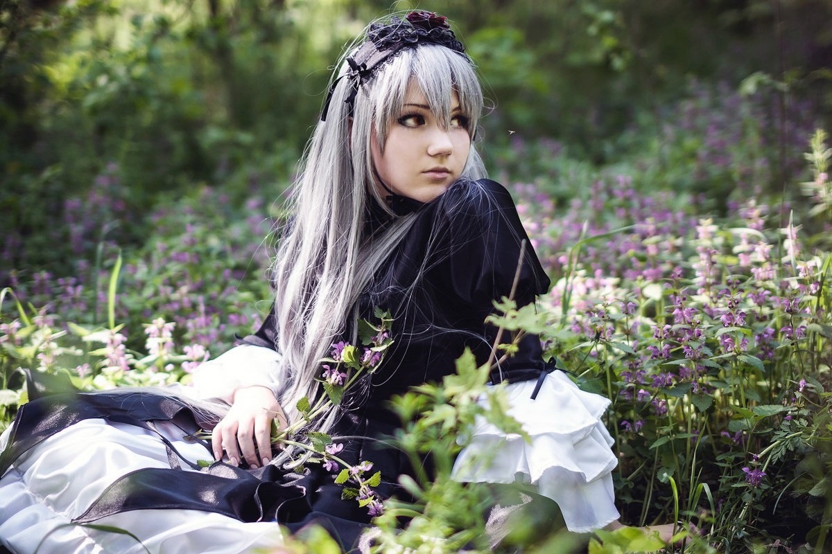 1girl bangs black_dress blurry closed_mouth depth_of_field dress flower frills gothic_lolita hairband lips lolita_fashion long_hair long_sleeves outdoors silver_hair sitting solo suigintou