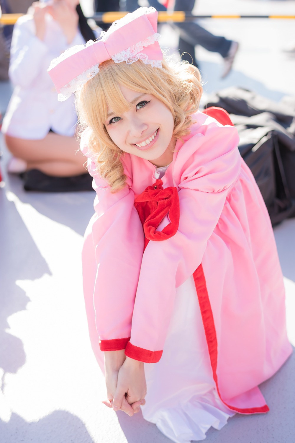 3d blonde_hair blurry blurry_background blurry_foreground depth_of_field dress hinaichigo hood looking_at_viewer photo short_hair smile solo teeth