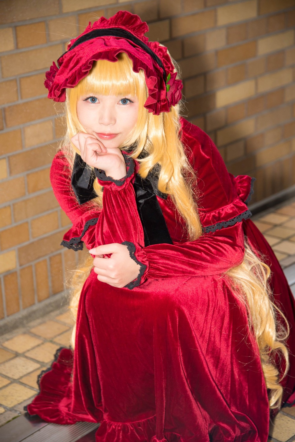 1girl bangs blonde_hair blue_eyes brick_wall dress flower lips lolita_fashion long_hair long_sleeves looking_at_viewer red_dress rose shinku sitting solo tile_floor tiles wall