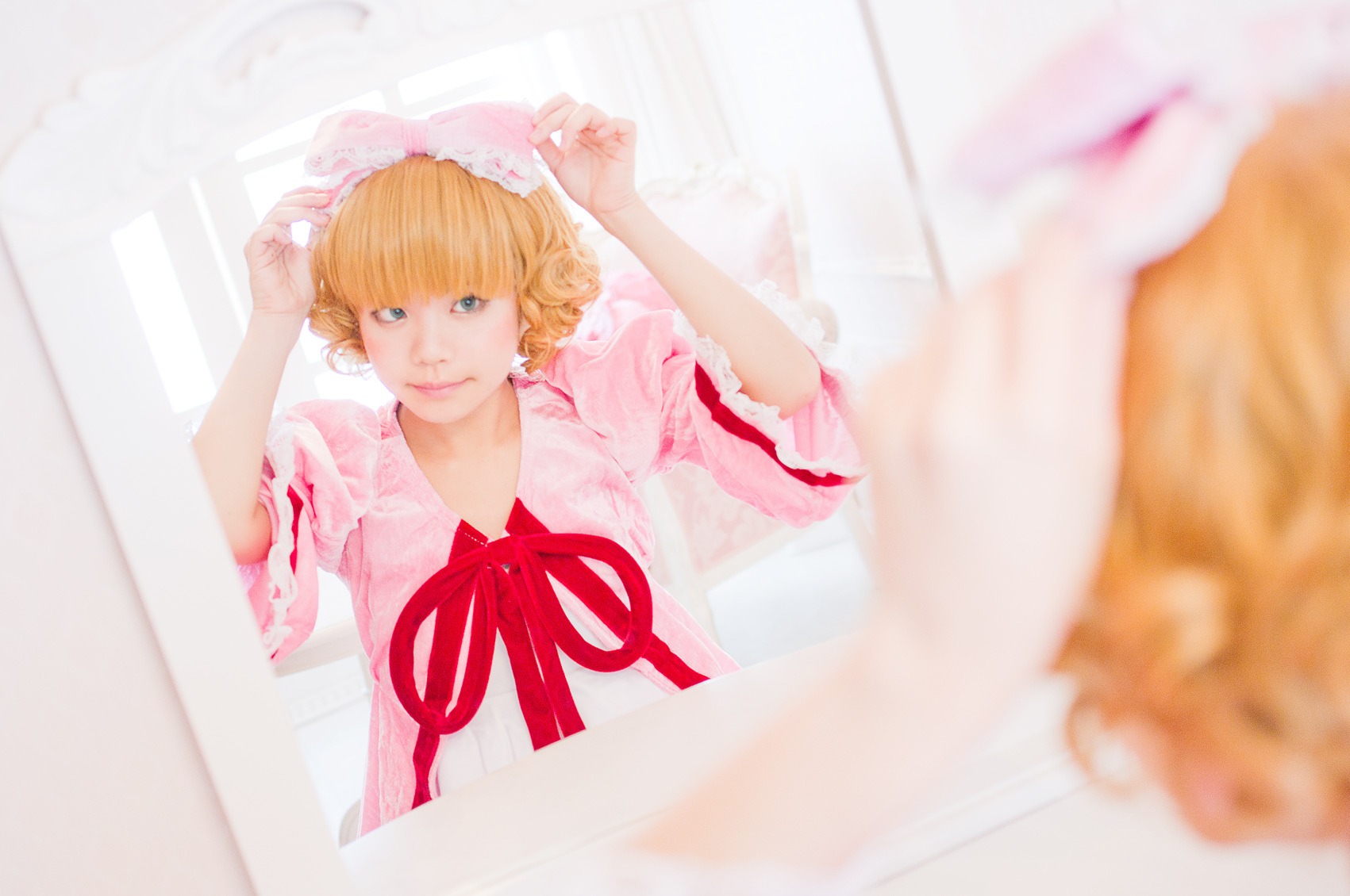 1girl bangs blonde_hair blue_eyes blurry blurry_foreground depth_of_field dress hat hinaichigo lips looking_at_viewer neck_ribbon photo ribbon short_hair smile solo wavy_hair