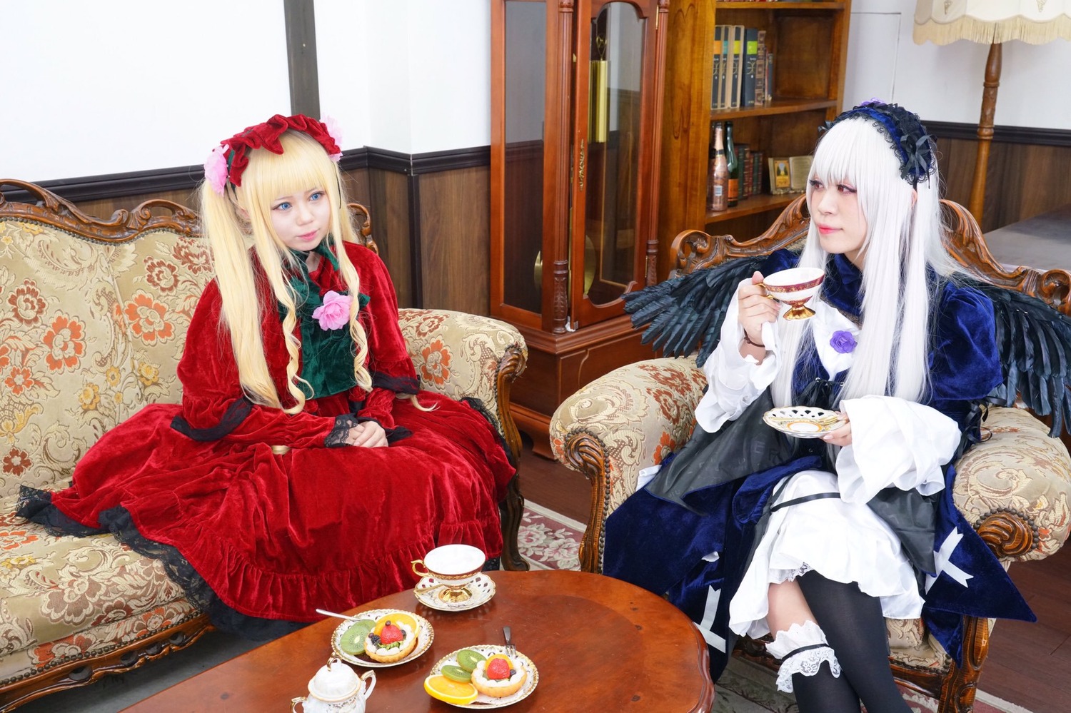 2girls blonde_hair blue_eyes bonnet cup dress flower food gothic_lolita lolita_fashion long_hair multiple_cosplay multiple_girls pastry shinku sitting table tagme tea teacup