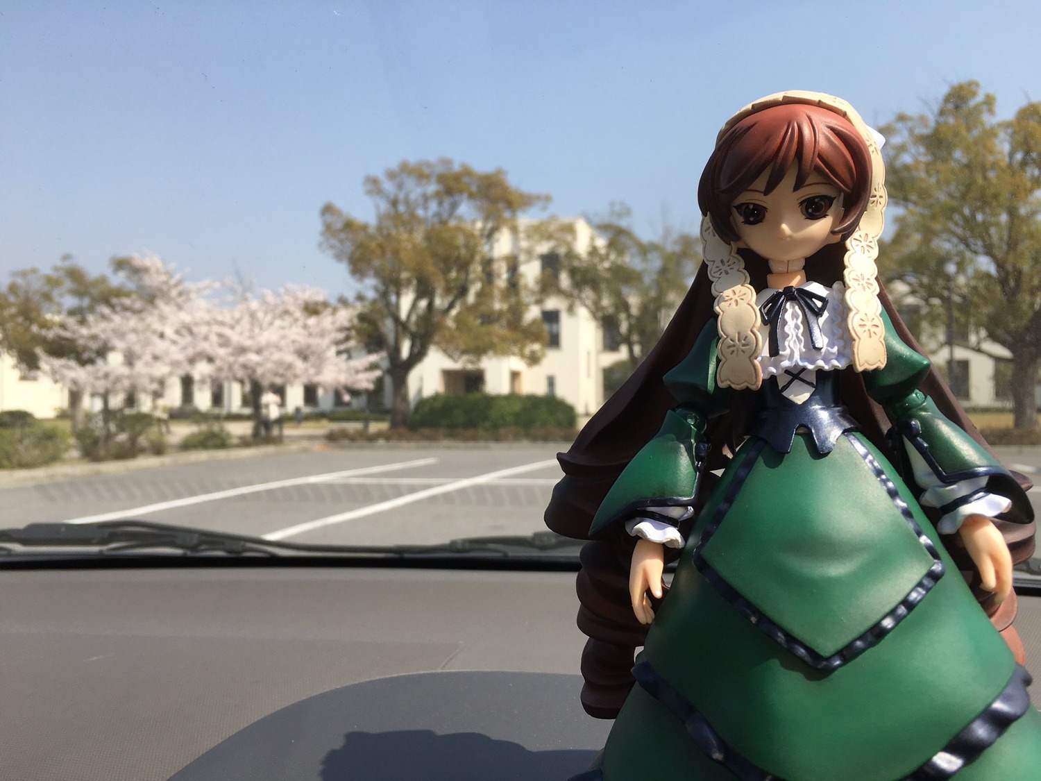 1girl blue_sky blurry brown_hair building day depth_of_field doll dress frills green_dress long_sleeves outdoors photo_background ribbon sky solo standing suiseiseki tree