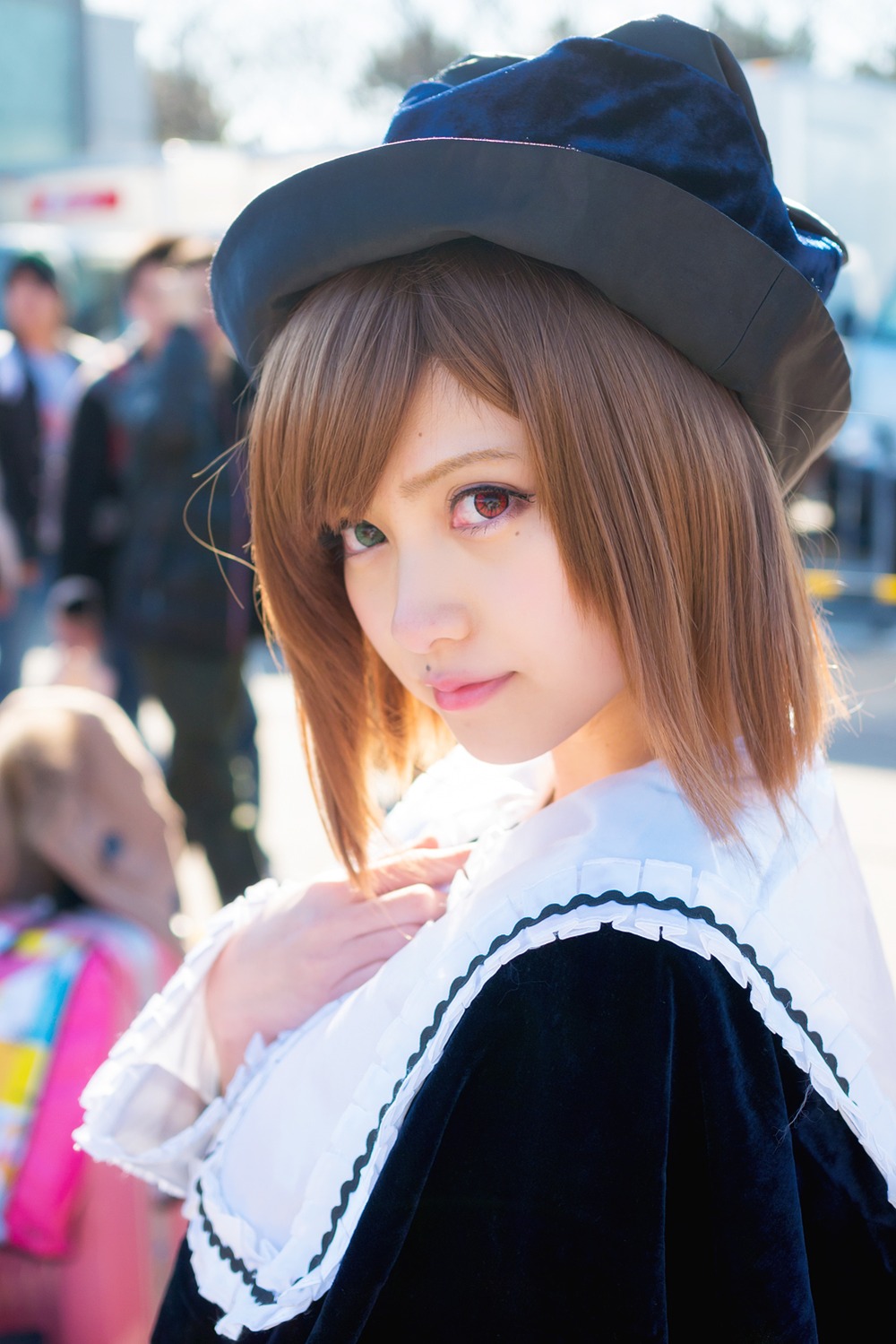 1girl blue_headwear blurry blurry_background blurry_foreground brown_hair depth_of_field hat heterochromia lips long_sleeves looking_at_viewer motion_blur outdoors photo red_eyes short_hair solo solo_focus souseiseki upper_body