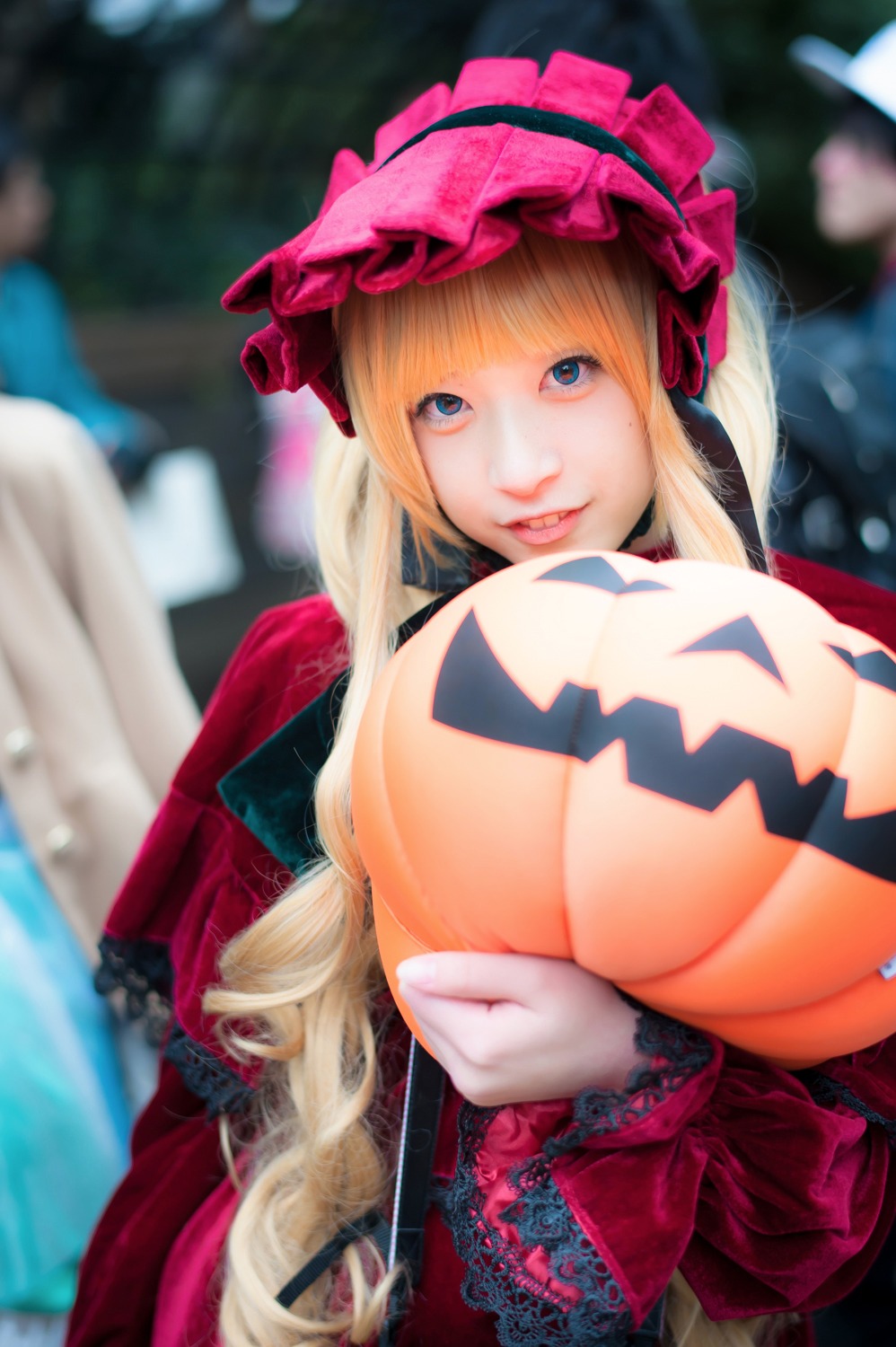 1girl blonde_hair blue_eyes blurry blurry_background blurry_foreground depth_of_field dress hat jack-o'-lantern long_hair looking_at_viewer photo shinku solo solo_focus