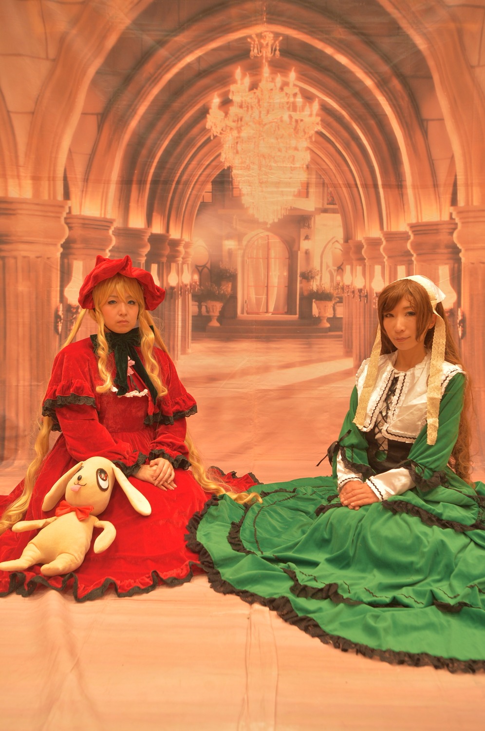 2girls blonde_hair bonnet dress green_dress hat indoors long_hair multiple_cosplay multiple_girls sitting stuffed_animal tagme