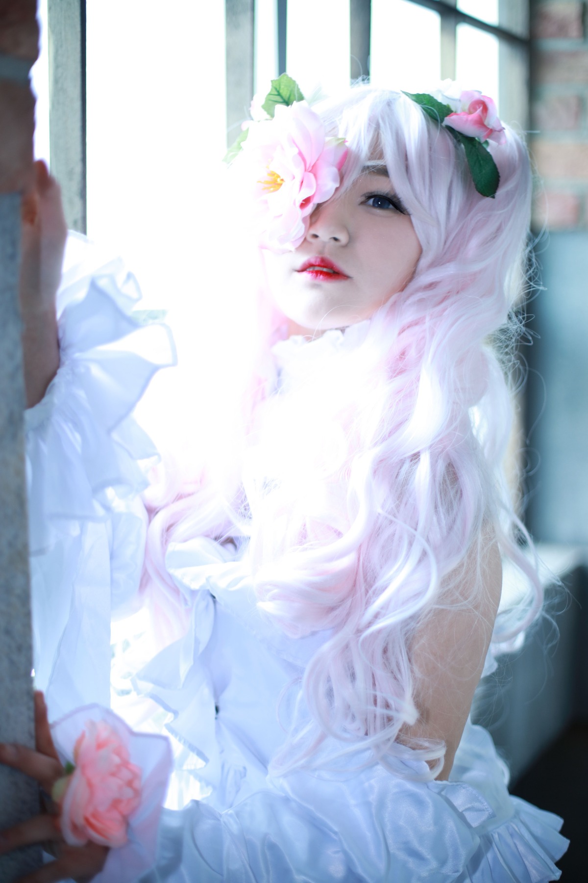 1girl blue_eyes blurry blurry_background blurry_foreground depth_of_field dress flower frills hair_ornament lips long_hair sitting solo white_hair