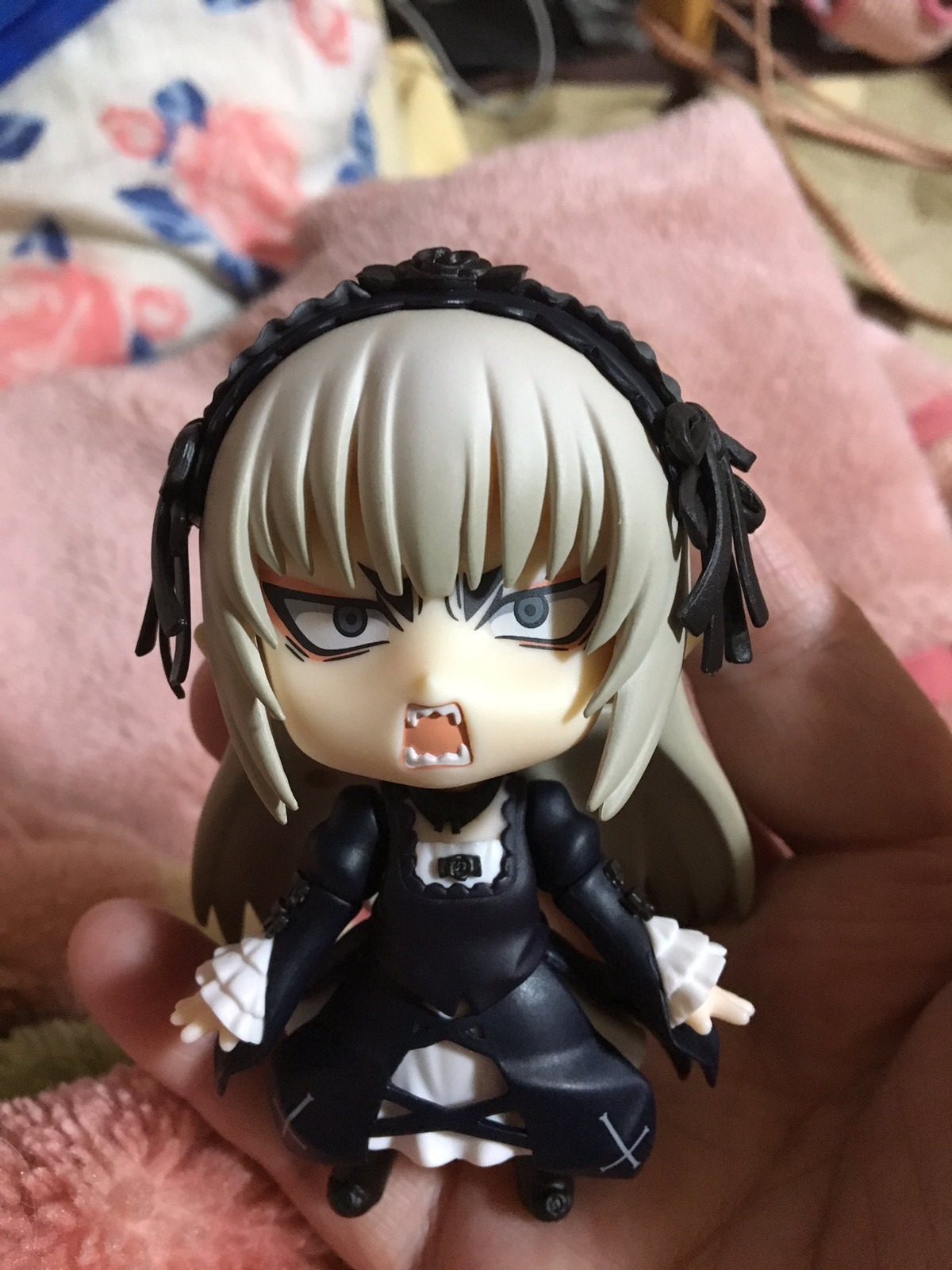 1girl black_dress blurry blurry_foreground chibi depth_of_field doll dress gothic_lolita hairband lolita_fashion lolita_hairband long_hair sharp_teeth solo suigintou teeth