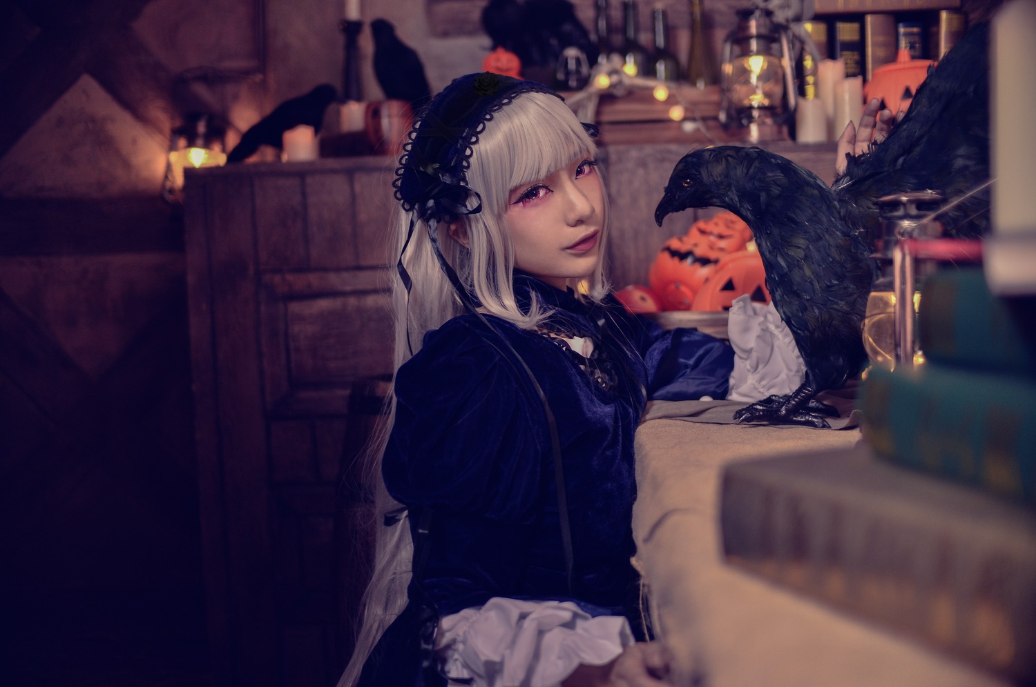 1girl bangs blurry blurry_background blurry_foreground bookshelf depth_of_field hairband indoors long_hair sitting solo suigintou