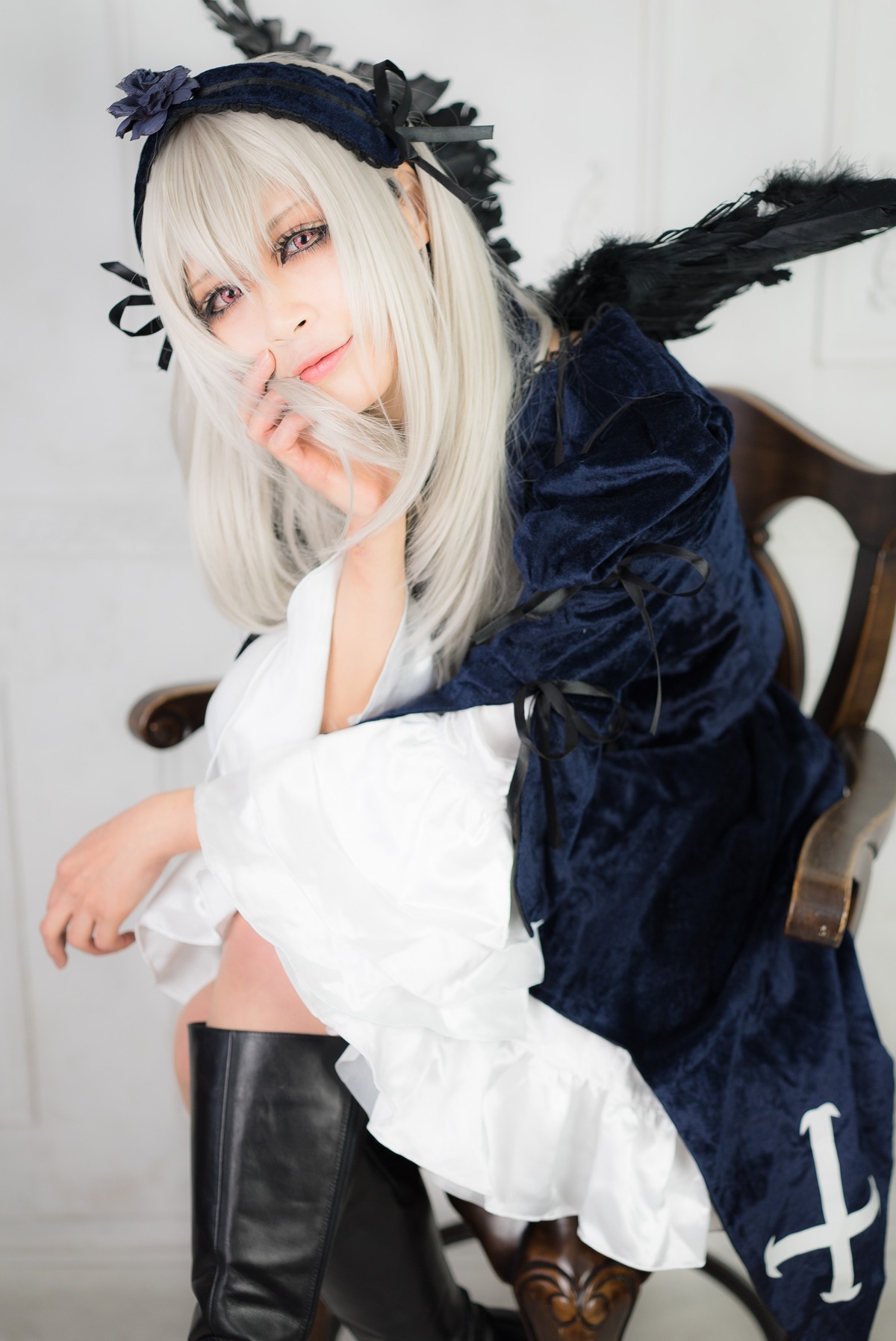 1girl black_wings blurry boots chair closed_mouth dress feathers hairband knee_boots lips long_hair long_sleeves looking_at_viewer photo sitting solo suigintou wings