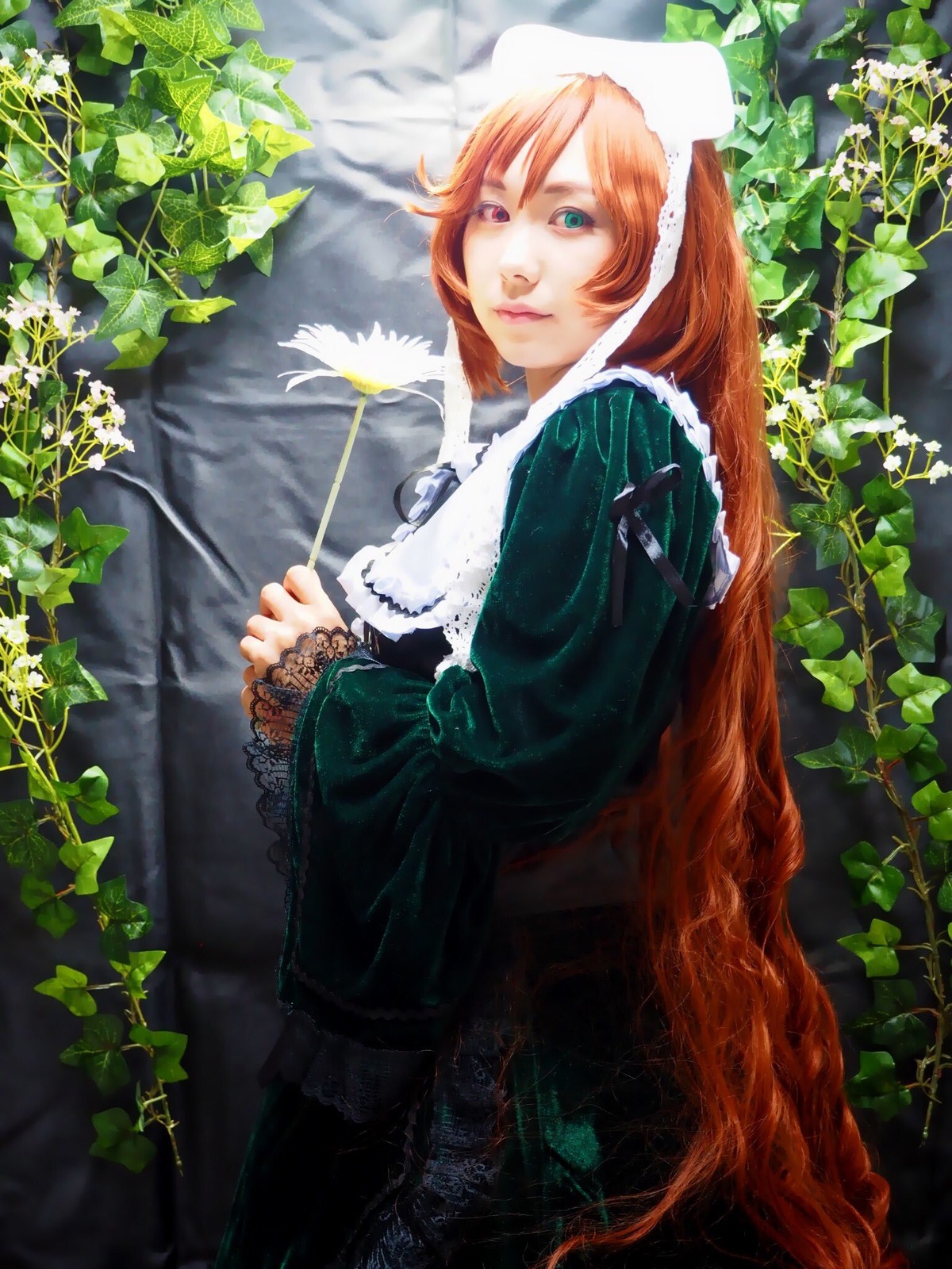 1girl dress from_side green_dress green_eyes heterochromia leaf lips long_hair long_sleeves looking_at_viewer orange_hair outdoors plant red_eyes solo standing suiseiseki tree very_long_hair vines watering_can