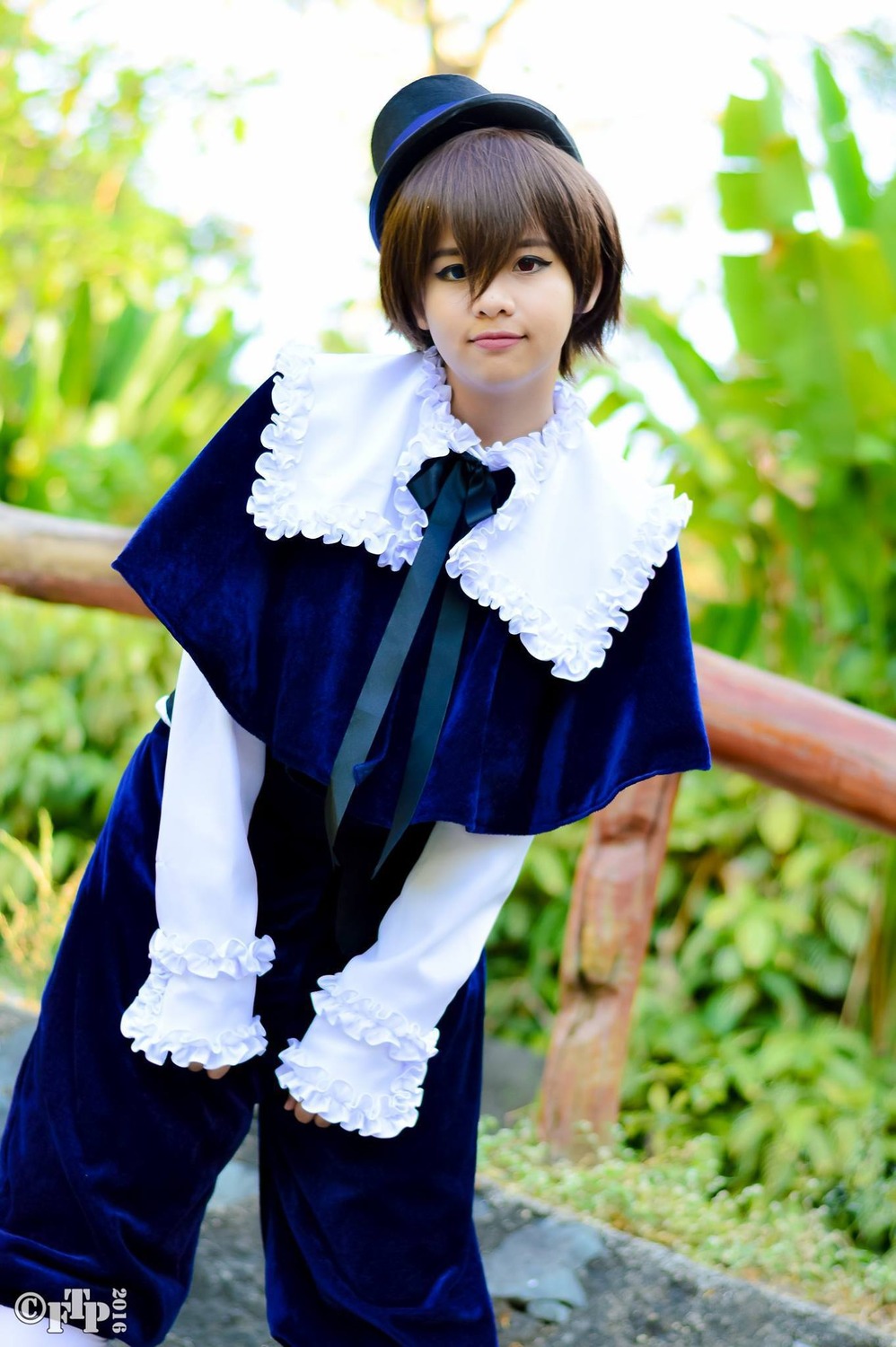 1girl blurry blurry_background brown_hair capelet depth_of_field dress hat lips long_sleeves looking_at_viewer outdoors solo souseiseki v_arms