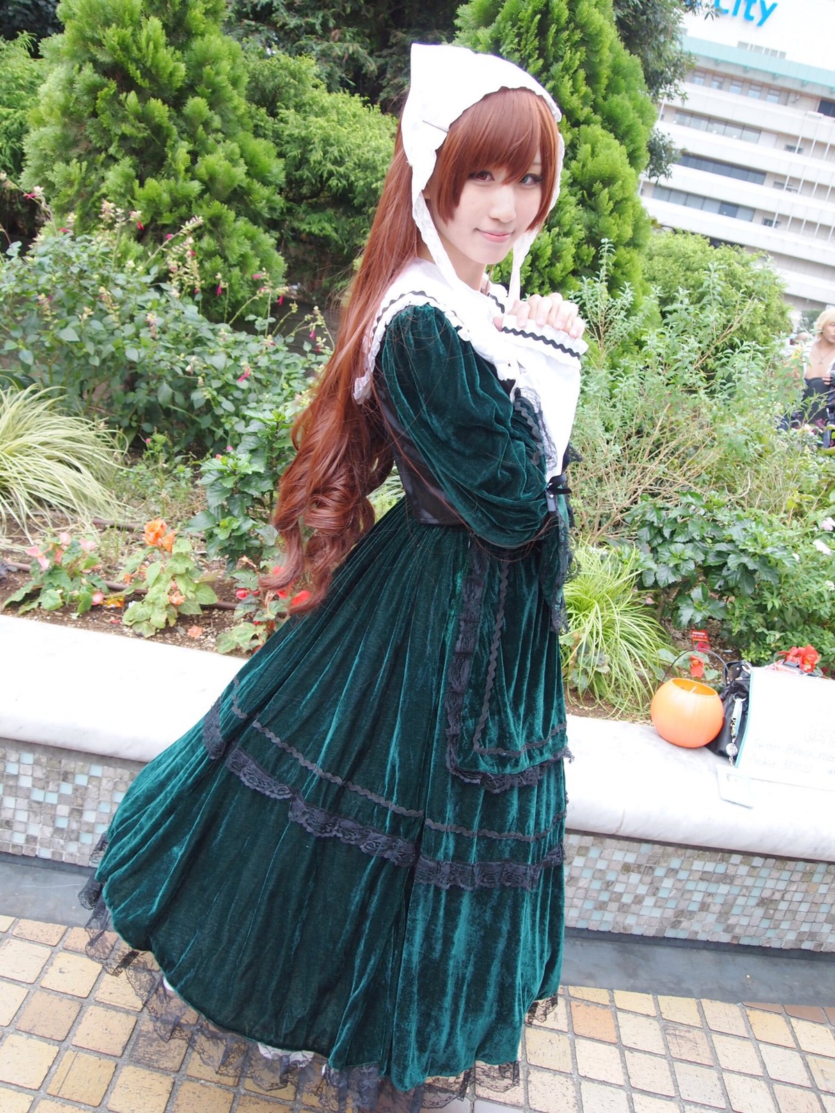 1girl blue_dress brown_hair dress flower head_scarf long_hair looking_at_viewer outdoors smile solo standing suiseiseki tiles tree