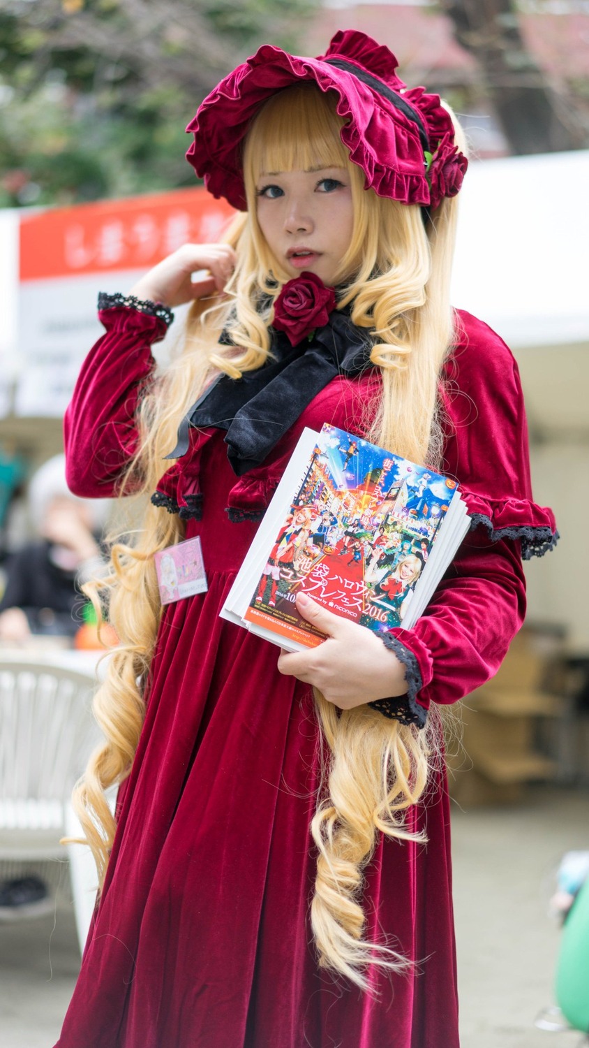 1girl blonde_hair blue_eyes blurry blurry_background blurry_foreground bonnet depth_of_field dress drill_hair flower hat holding lips long_hair long_sleeves looking_at_viewer photo red_dress rose shinku solo solo_focus very_long_hair