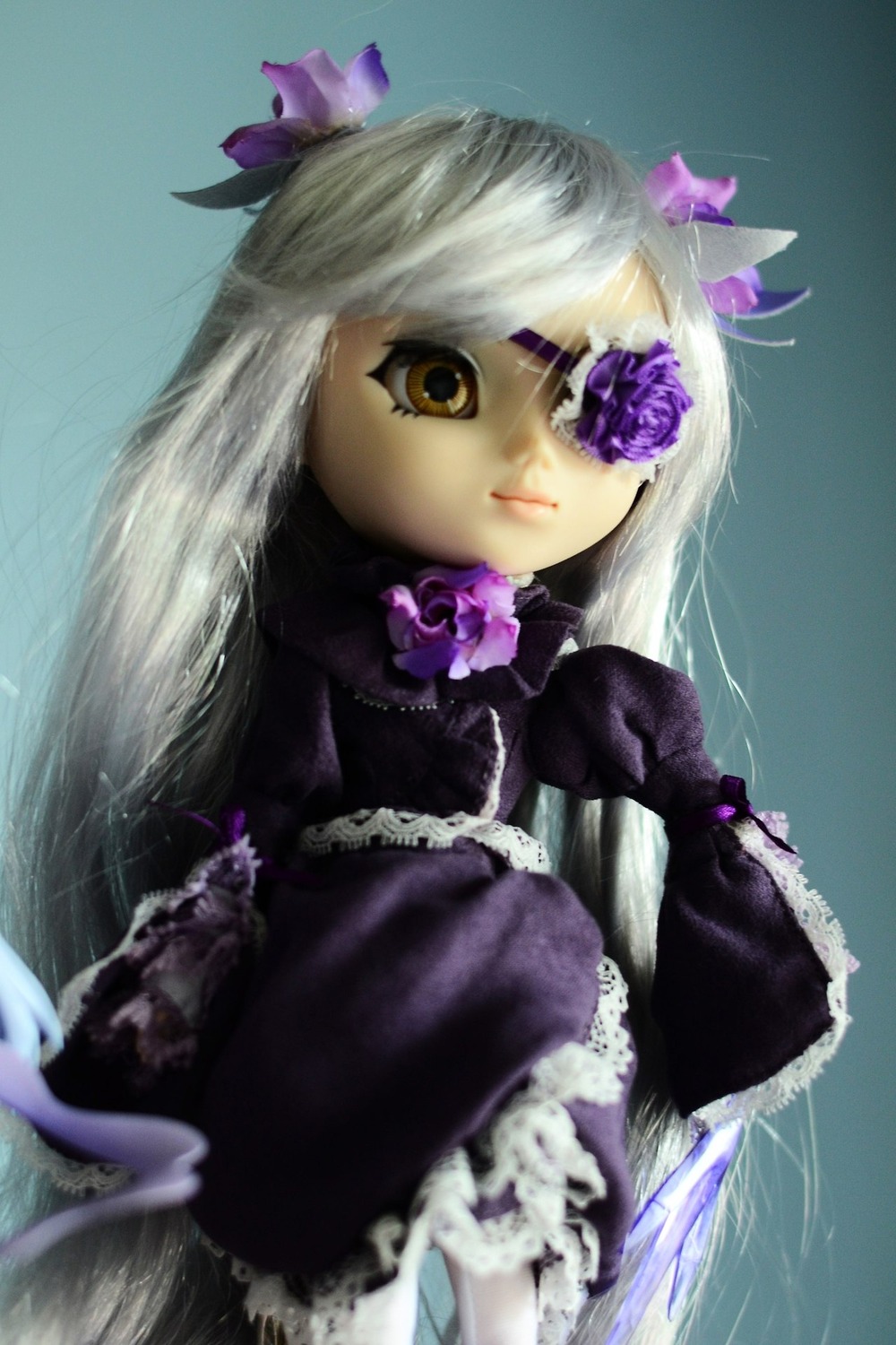 1girl barasuishou bow doll dress eyepatch flower frills gothic_lolita lolita_fashion long_hair long_sleeves purple_bow purple_flower silver_hair solo