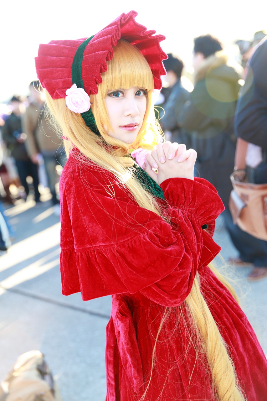 1girl bangs blonde_hair blue_eyes blurry blurry_background blurry_foreground bonnet capelet depth_of_field dress flower lace long_hair photo red_dress shinku solo solo_focus