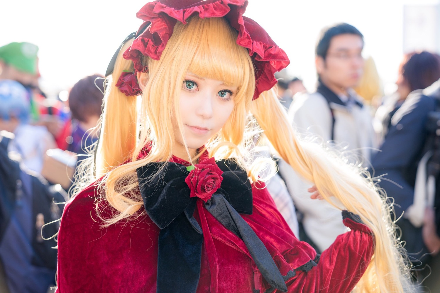 1girl bangs blonde_hair blue_eyes blurry blurry_background blurry_foreground depth_of_field dress figure flower frills hat lips long_hair looking_at_viewer photo red_rose rose shinku smile solo solo_focus