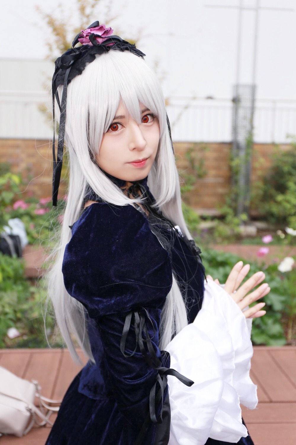 1girl 3d black_dress blurry blurry_background blurry_foreground depth_of_field dress gothic_lolita hairband lips lolita_fashion long_hair long_sleeves looking_at_viewer photo red_eyes solo suigintou white_hair