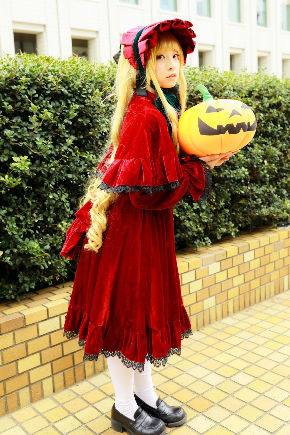 1girl blonde_hair bonnet chain-link_fence dress fence frills long_hair looking_at_viewer looking_back outdoors pavement red_dress shinku shoes solo standing tile_floor tiles white_legwear