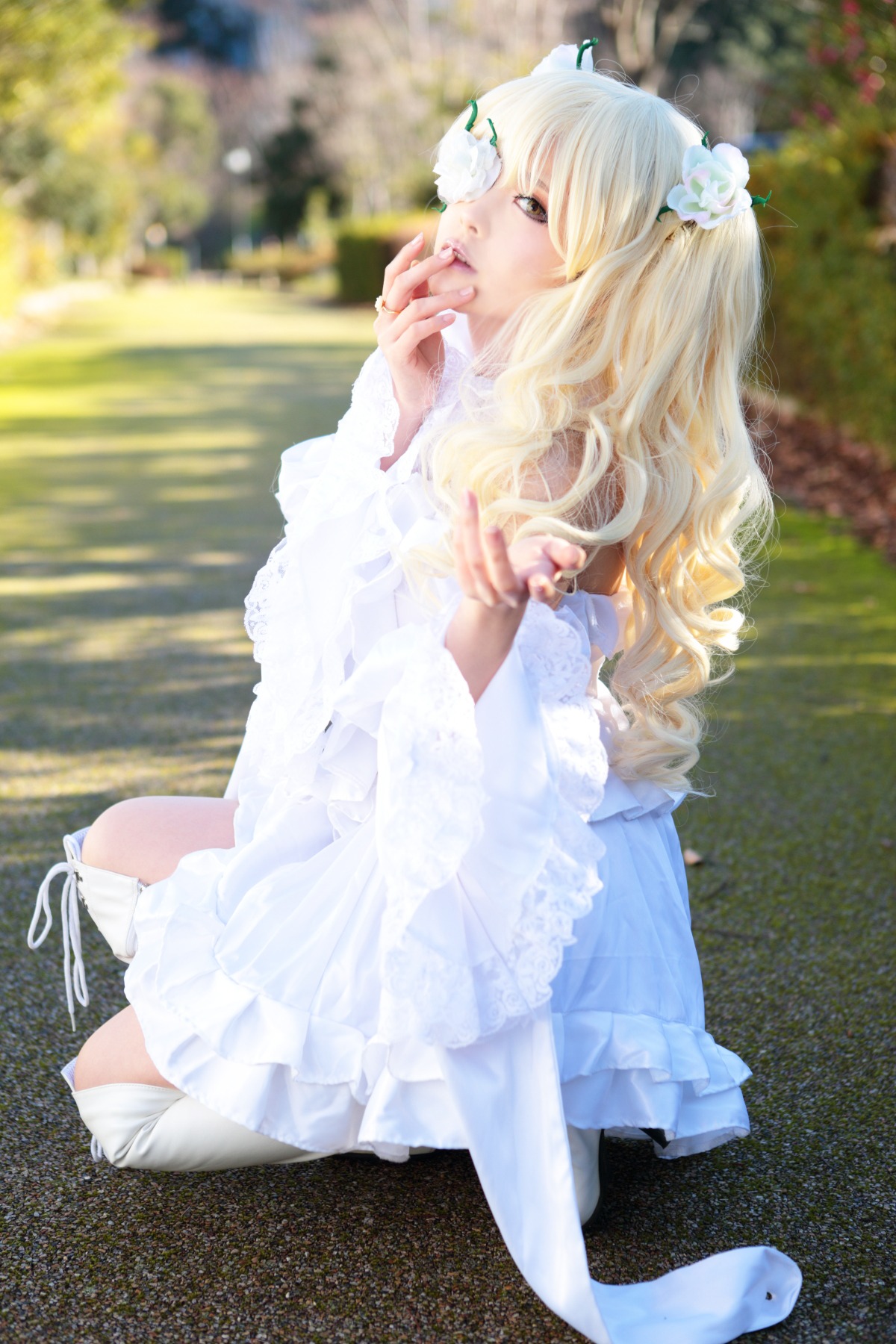 1girl blonde_hair blurry blurry_background depth_of_field dress flower hair_flower hair_ornament kirakishou long_hair photo sitting solo wavy_hair white_dress