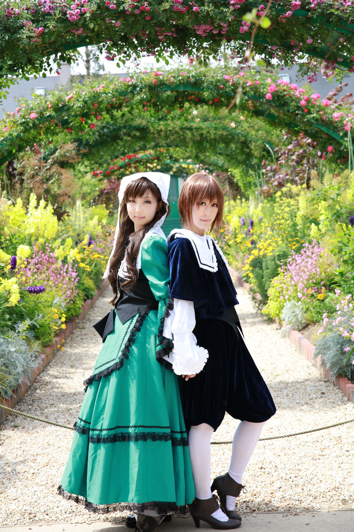 2girls black_footwear braid brown_hair day dress flower long_hair looking_at_viewer multiple_cosplay multiple_girls outdoors smile standing tagme white_legwear