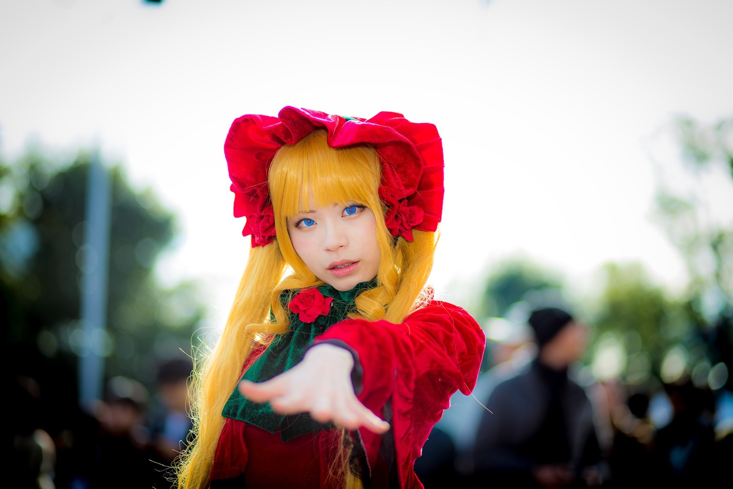 1girl blonde_hair blue_eyes blurry blurry_background blurry_foreground bonnet depth_of_field dress flower lips long_hair looking_at_viewer red_dress red_flower rose shinku solo