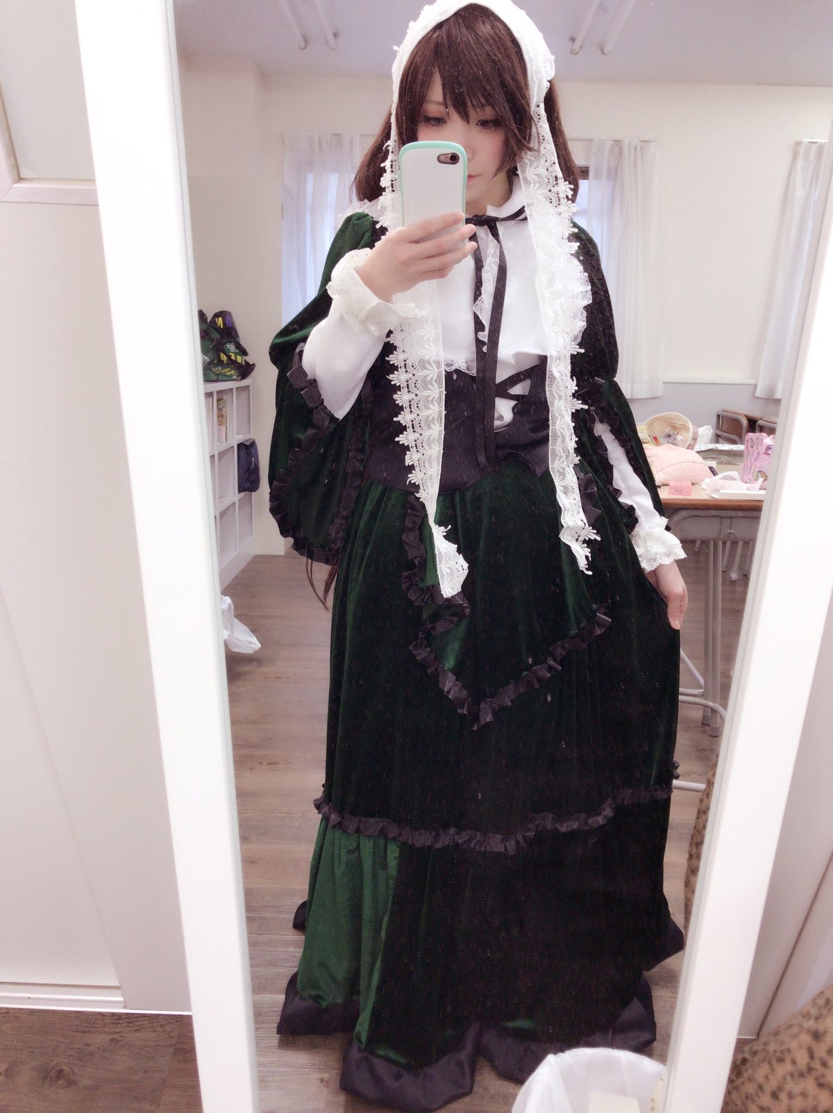 1girl bangs black_dress brown_hair cellphone dress frills holding holding_phone indoors long_hair long_sleeves maid mirror phone reflection smartphone solo standing suiseiseki
