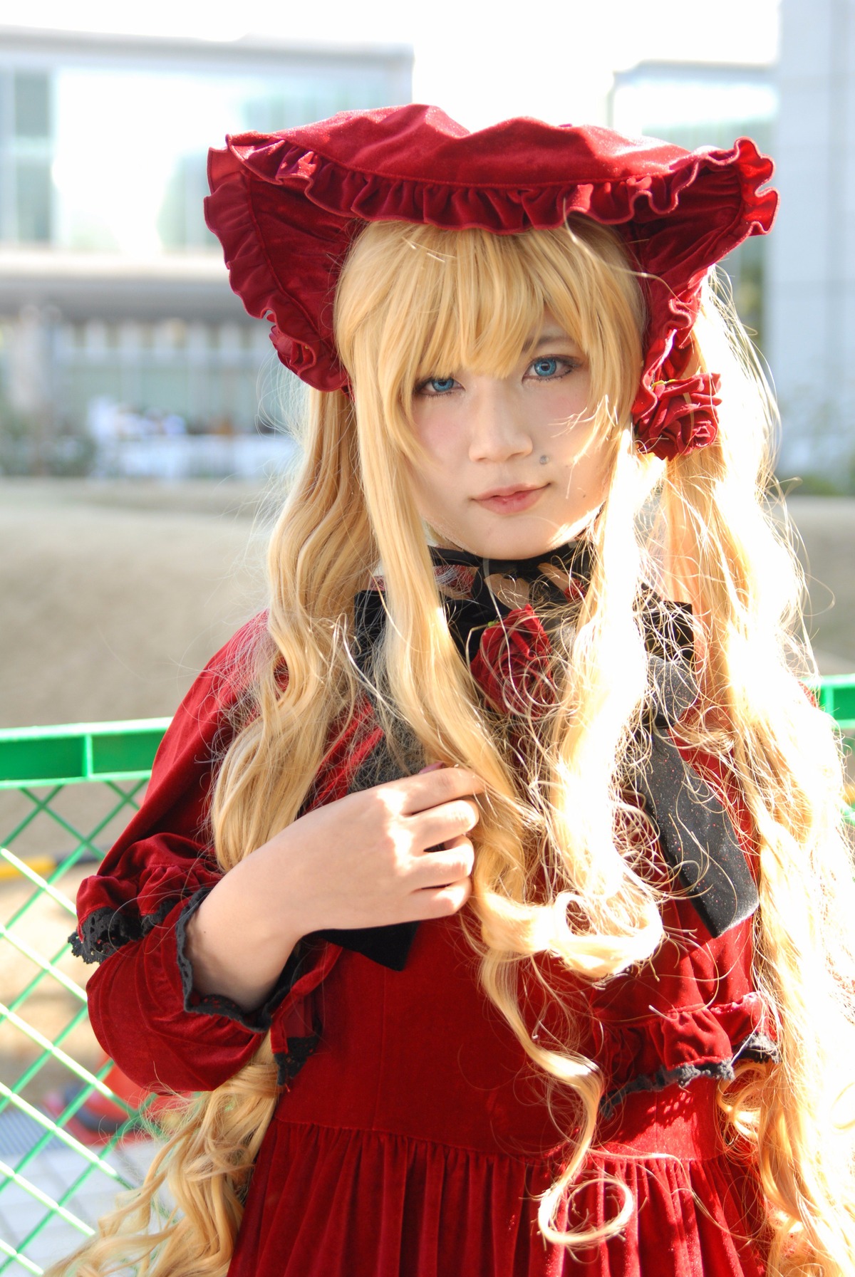 1girl bangs blonde_hair blue_eyes blurry blurry_background bonnet depth_of_field dress flower lips long_hair long_sleeves looking_at_viewer red_dress rose shinku smile solo