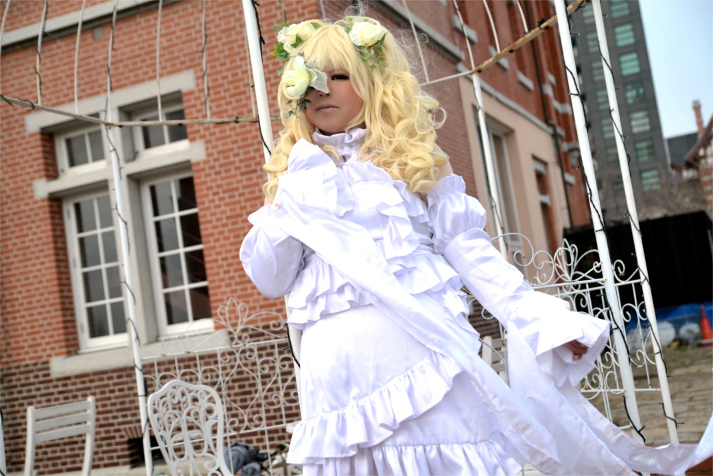 1girl blonde_hair blurry building closed_eyes dark_skin day depth_of_field dress facing_viewer frilled_dress frills gloves kirakishou long_hair long_sleeves outdoors sheep_horns solo white_dress