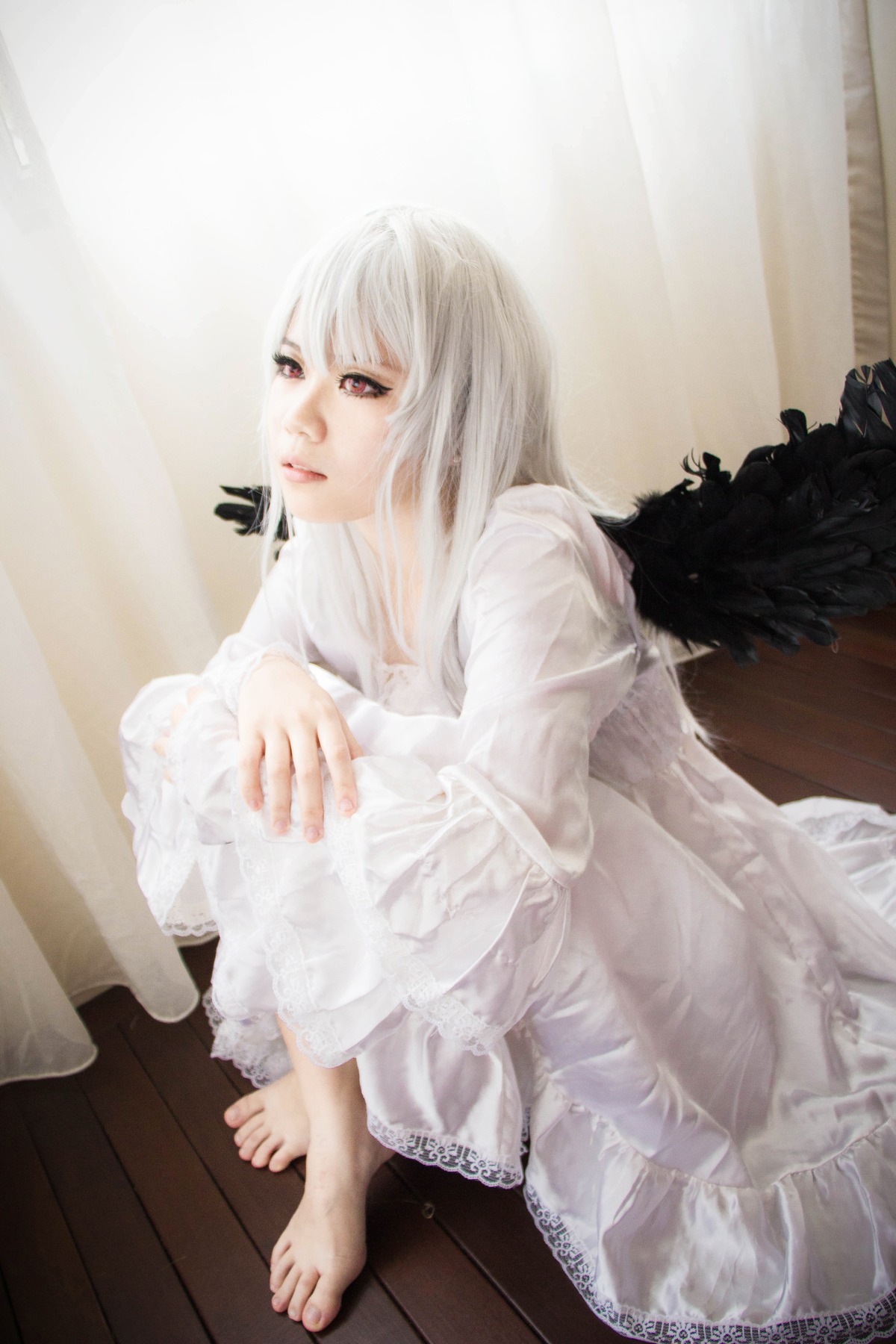 1girl albino barefoot dress feathered_wings feathers indoors lips long_hair long_sleeves red_eyes sitting solo suigintou white_dress white_hair wings wooden_floor