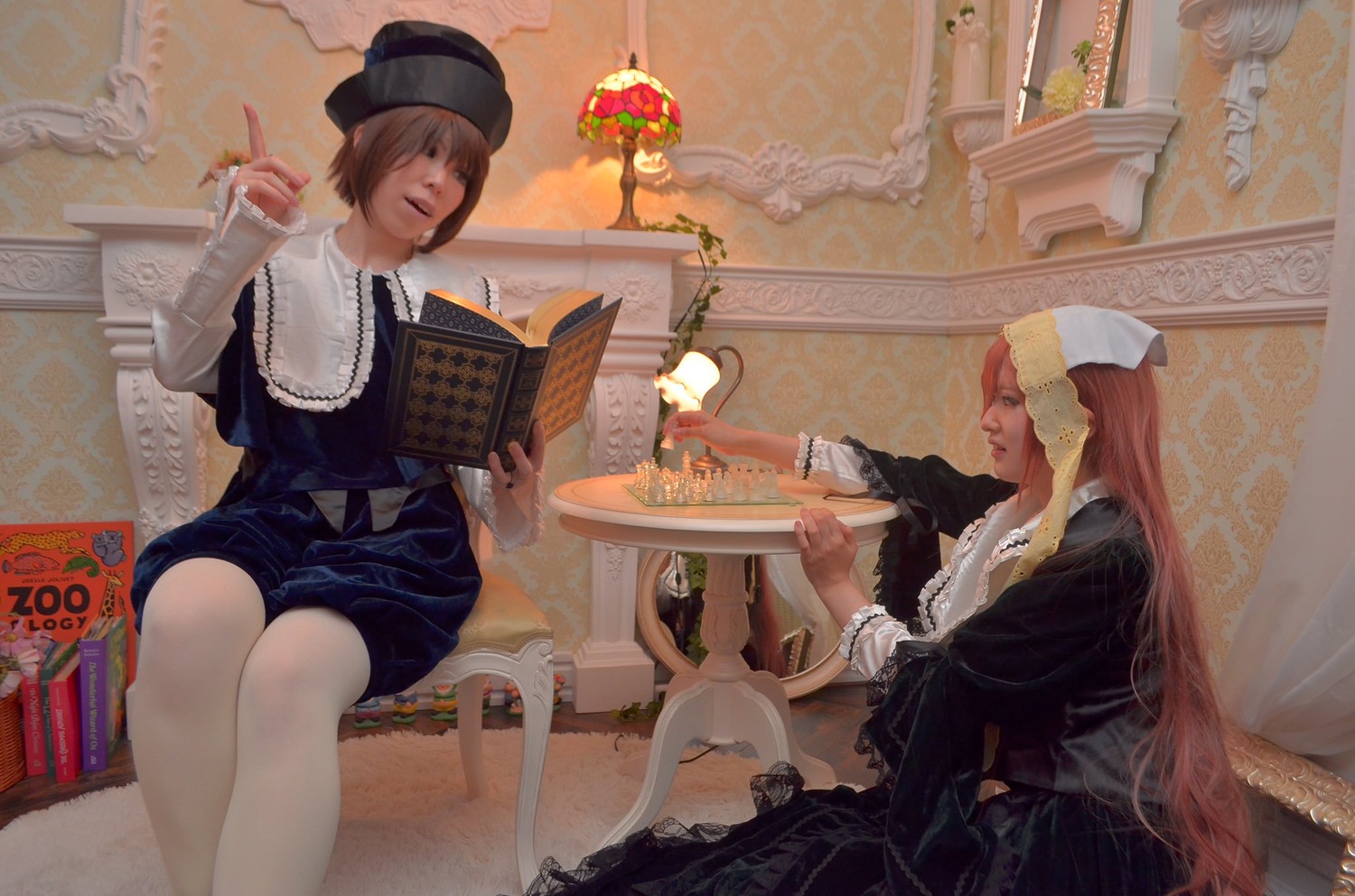 2girls book brown_hair closed_eyes dress hat indoors long_hair multiple_cosplay multiple_girls short_hair sitting table tagme