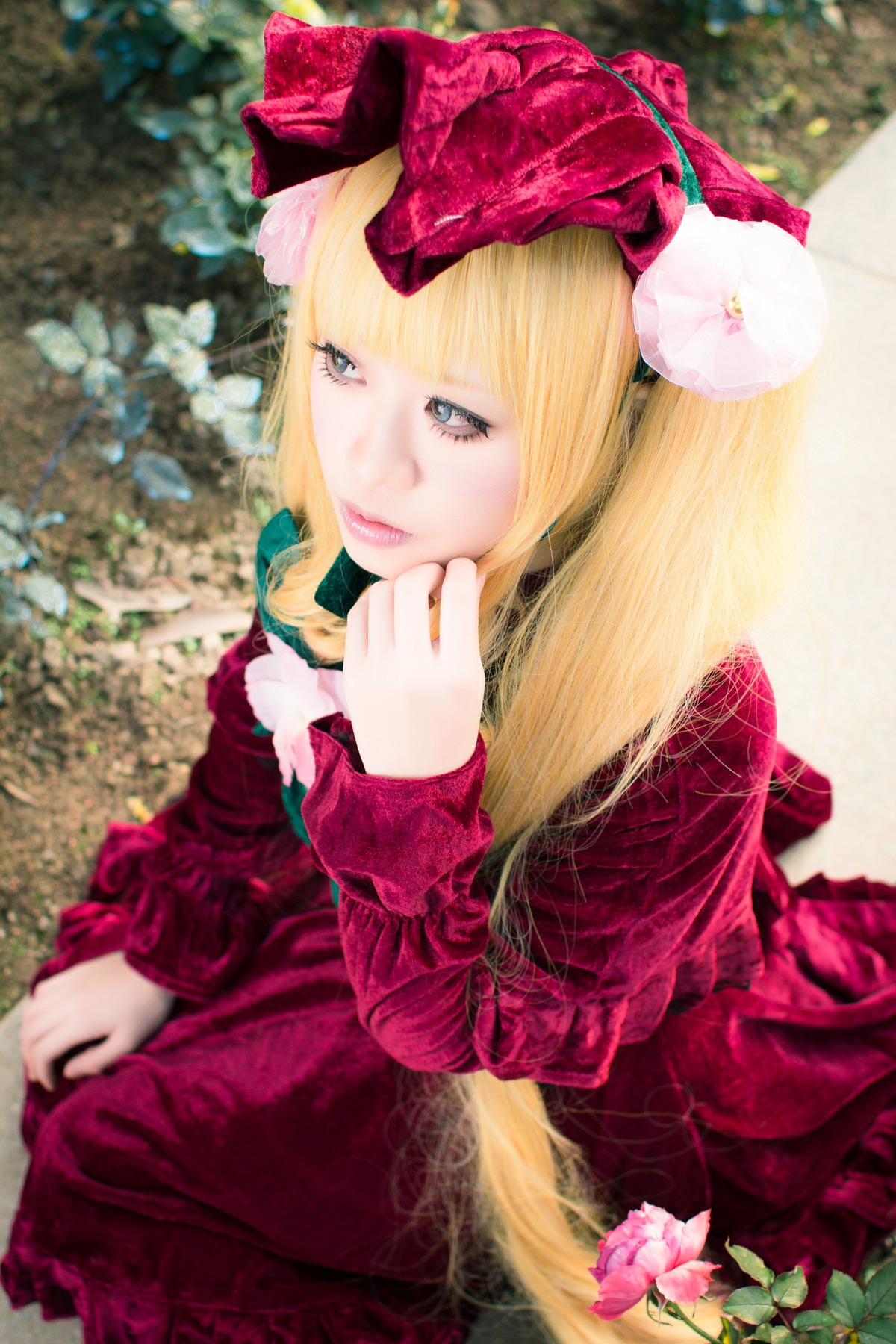 1girl bangs blonde_hair blue_eyes blurry bow depth_of_field dress flower hair_flower hair_ornament lips long_hair realistic red_dress shinku sitting solo